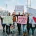 Group of activists hold signs advocating for justice and equality during a street protest.