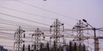 Construction site with cranes and power lines in Mumbai during evening hours.