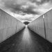 Symmetrical walkway in Canberra with dramatic clouds and modern architecture.