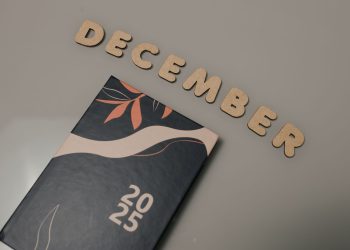 A 2025 planner displayed with wooden letters spelling 'December' on a neutral background.