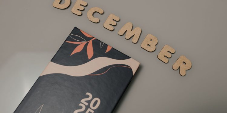 A 2025 planner displayed with wooden letters spelling 'December' on a neutral background.