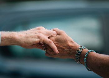 A heartfelt image of two elderly individuals holding hands, symbolizing love and support.