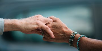 A heartfelt image of two elderly individuals holding hands, symbolizing love and support.