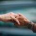 A heartfelt image of two elderly individuals holding hands, symbolizing love and support.