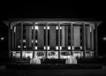 Monochrome image showcasing the National Library of Australia with illuminating fountains at night.