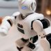 Close-up of a futuristic toy robot with blue eyes, showcasing modern technology indoors.