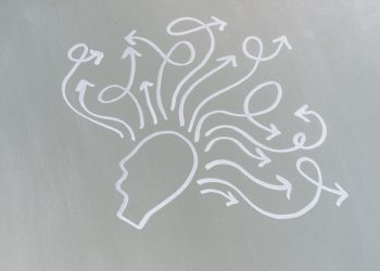Chalk drawing of a head with swirling arrows represents mental activity and thought process.