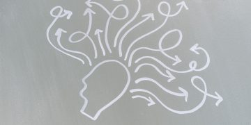 Chalk drawing of a head with swirling arrows represents mental activity and thought process.