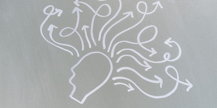 Chalk drawing of a head with swirling arrows represents mental activity and thought process.