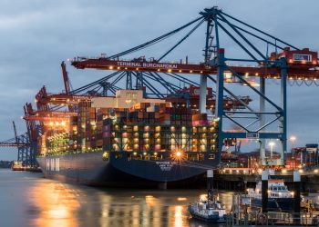 Container ships moored at Terminal Burchardkai in Hamburg, Germany during evening hours.