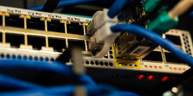 Close-up image of ethernet cables plugged into a network switch, showcasing IT infrastructure.