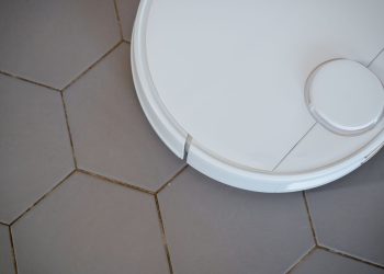 Close-up of a robotic vacuum cleaner on hexagonal tiles for efficient cleaning.
