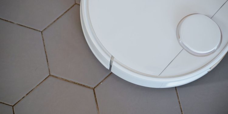 Close-up of a robotic vacuum cleaner on hexagonal tiles for efficient cleaning.
