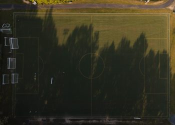 A stunning aerial view of an empty soccer field with sunlit shadows, captured in Virginia.