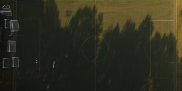 A stunning aerial view of an empty soccer field with sunlit shadows, captured in Virginia.