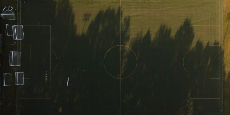 A stunning aerial view of an empty soccer field with sunlit shadows, captured in Virginia.