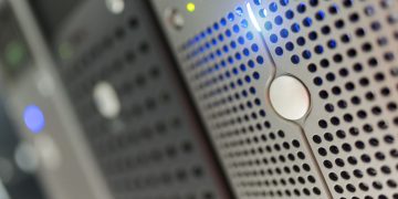 Focused detail of a modern server rack with blue LED indicators in a data center.