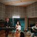 A diverse band practicing music in a professional recording studio setting.