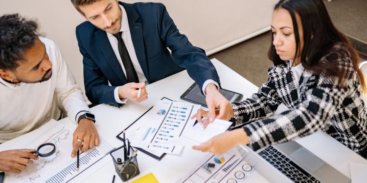 Business professionals engaging in a collaborative meeting with charts and documents.