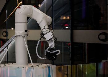 A white robotic arm operating indoors with a modern design and advanced technology.