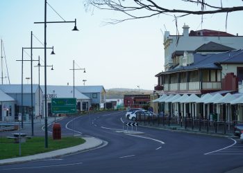 A scenic street in Strahan, Tasmania, showcasing historic buildings and modern architecture.