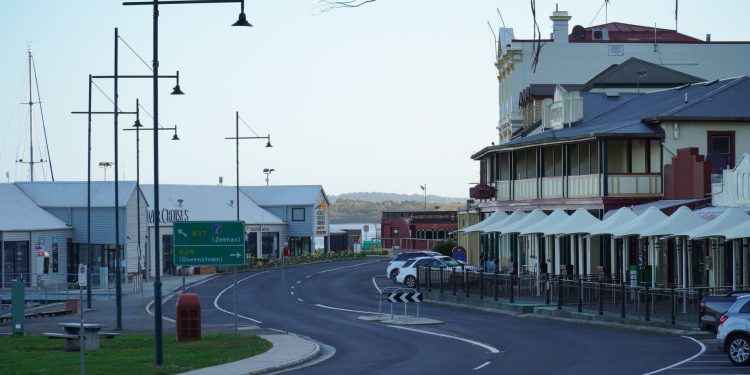 A scenic street in Strahan, Tasmania, showcasing historic buildings and modern architecture.