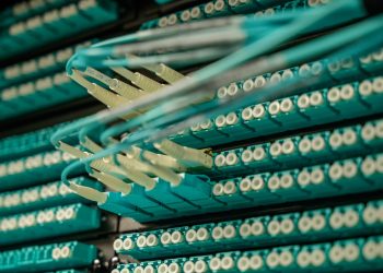 Detailed view of fiber optic cables connected to a server rack, showcasing modern technology.