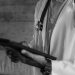 Black-and-white photo of a medical professional holding a tablet, focusing on digital health technology.