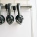 Three black headsets neatly organized on a whiteboard hook, emphasizing tech and communication.