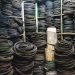 A cluttered storage room filled with stacks of rubber belts and industrial equipment.