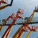 Vibrant boom lifts reaching skyward, showcasing industrial machinery against a clear blue backdrop.