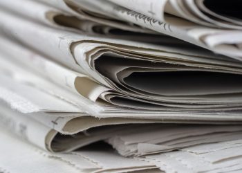 A detailed close-up view of stacked newspapers, highlighting textures and layers.