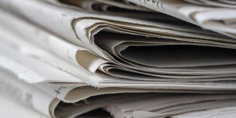 A detailed close-up view of stacked newspapers, highlighting textures and layers.