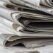 A detailed close-up view of stacked newspapers, highlighting textures and layers.