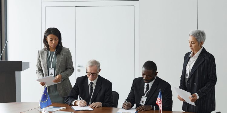 Business leaders signing a significant agreement in a conference room setting.