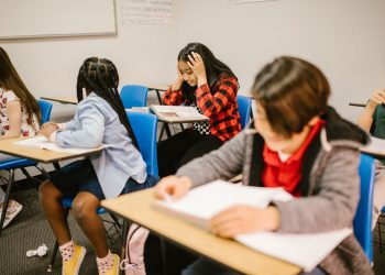 Diverse group of students engaged in study session inside a classroom setting.