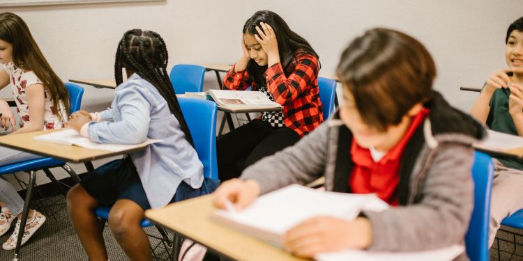 Diverse group of students engaged in study session inside a classroom setting.