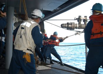 US Navy 050602-N-4702D-052 Boatswain's Mate 2nd Class Arvin Illaccabrera helps guide the Royal Australian Navy warship HMAS Success (AOR 304) fuel probe into a refueling station.jpg
