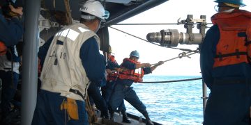US Navy 050602-N-4702D-052 Boatswain's Mate 2nd Class Arvin Illaccabrera helps guide the Royal Australian Navy warship HMAS Success (AOR 304) fuel probe into a refueling station.jpg