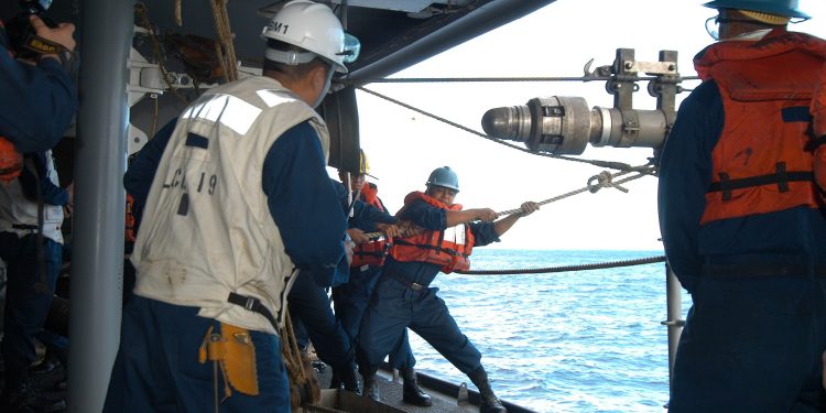 US Navy 050602-N-4702D-052 Boatswain's Mate 2nd Class Arvin Illaccabrera helps guide the Royal Australian Navy warship HMAS Success (AOR 304) fuel probe into a refueling station.jpg
