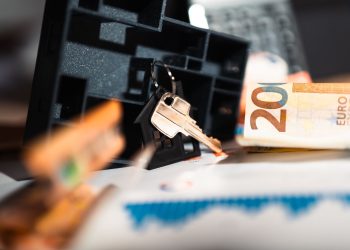 Keys with a house model, Euro bills, and charts suggesting real estate and financial themes.