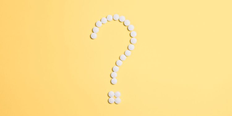 White pills arranged into a question mark shape on a vibrant yellow background.