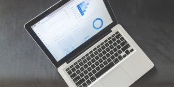 Overhead view of a laptop showing data visualizations and charts on its screen.