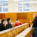 A diverse group of university students engaging with a professor during a classroom lecture.