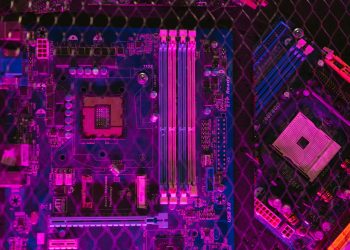 Close-up of a colorful motherboard showcasing intricate circuitry and glowing neon elements.