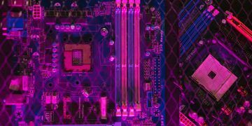 Close-up of a colorful motherboard showcasing intricate circuitry and glowing neon elements.