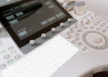 Detailed view of a medical ultrasound machine control panel with buttons and screen.