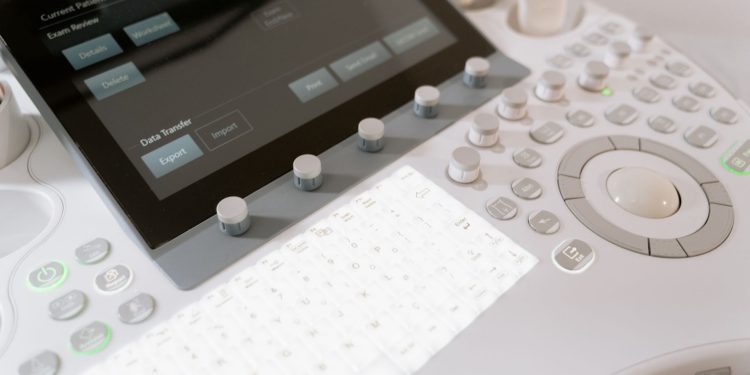 Detailed view of a medical ultrasound machine control panel with buttons and screen.