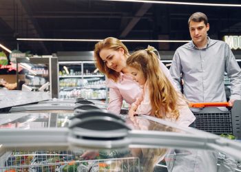 A happy family shopping in the supermarket's freezer section, emphasizing togetherness and love.