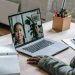 From above of crop confident African American female teacher sitting in classroom and teaching multiethnic pupils remotely on laptop during coronavirus pandemic